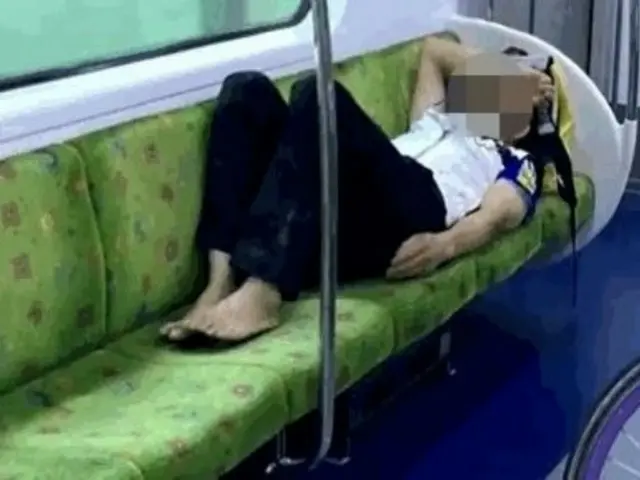 Man sleeping barefoot on subway, occupying four seats (South Korea)