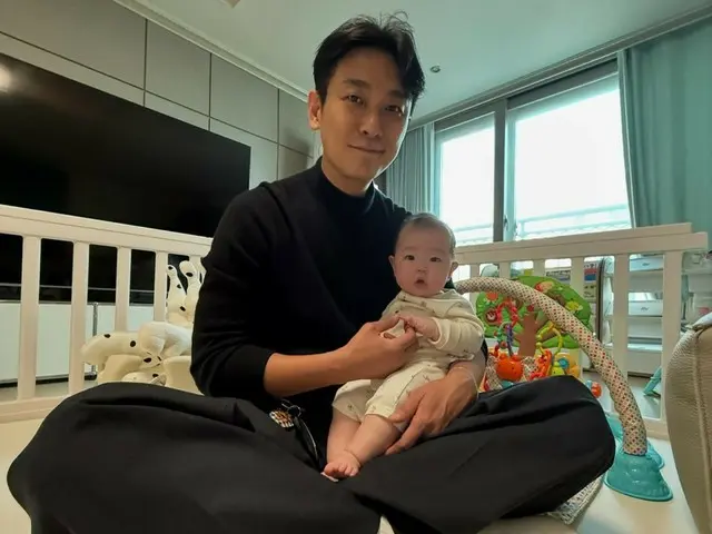 Actor Joo Ji Hoon smiles as he holds his best friend Jang Su-won's (SECHSKIES) daughter