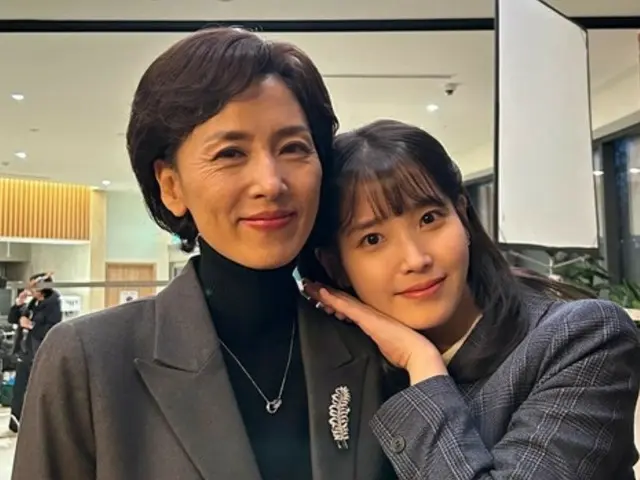 IU is seen snuggling up to the late actress Kang Myung-ju, who passed away in February this year... a different look from her TV series