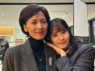 IU is seen snuggling up to the late actress Kang Myung-ju, who passed away in February this year... a different look from her TV series