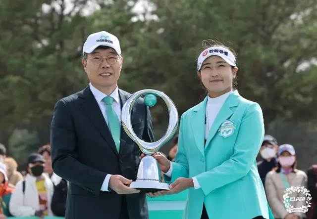 iM金融グループのファン・ビョンウ会長からトロフィーを受け取るキム・ミンジュ（写真：KLPGA）