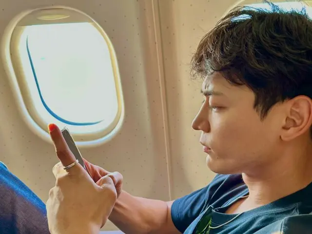 "SHINee" Minho looks serious on the plane..."I'm not angry...photo by taemin."