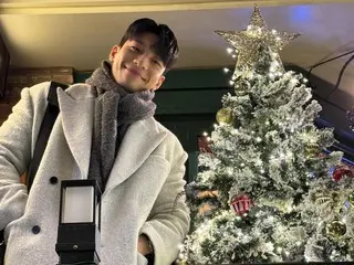 Actor Wi HaJun, smiling sweetly next to the Christmas tree