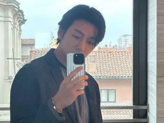Actor Ji Chang Wook takes a mirror selfie with the streets of Milan in the background