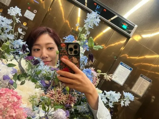 Actress Park Shin Hye, holding a bouquet of flowers, poses in the mirror in an elevator... a goddess of beauty among flowers