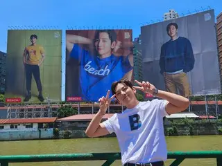 Actor Ji Chang Wook takes a photo with his huge advertisement in Manila, Philippines